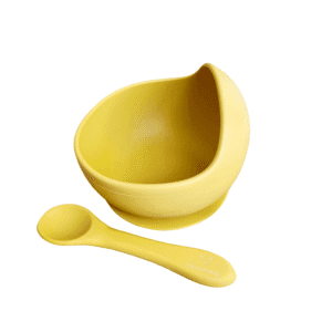 Cuenco de silicona en color ocre con ventosa y cuchara flexible a juego.