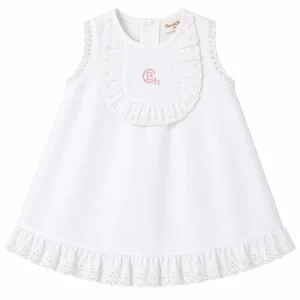 Vestido blanco para bebé niña Colección York de Chocolat Baby confeccionado en tejido de piqué con detalles de puntilla bordada y bordado rosa.