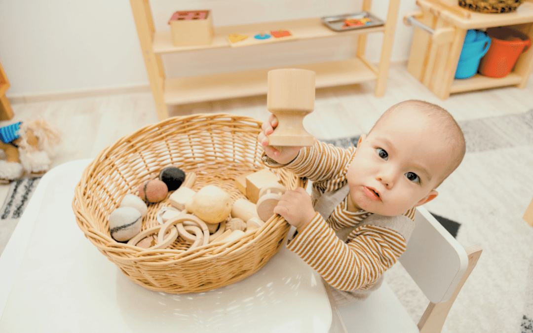 Niño pequeño jugando con juguetes sensoriales de madera en un espacio Montessori.