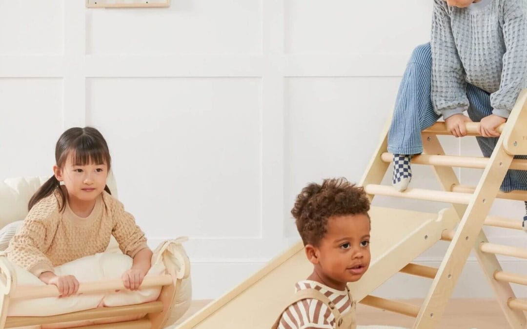 Niño pequeño jugando libremente con juguetes de madera en un espacio luminoso.