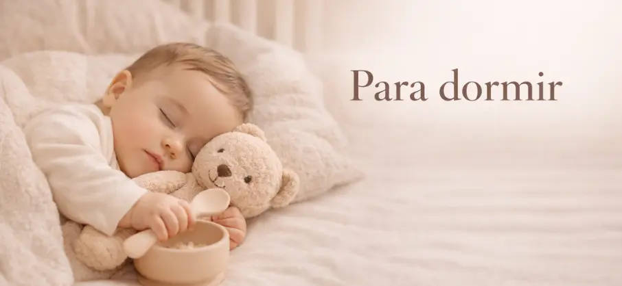 bebé dormido abrazando un oso al que jugaba a dar de comer. Con una almohada